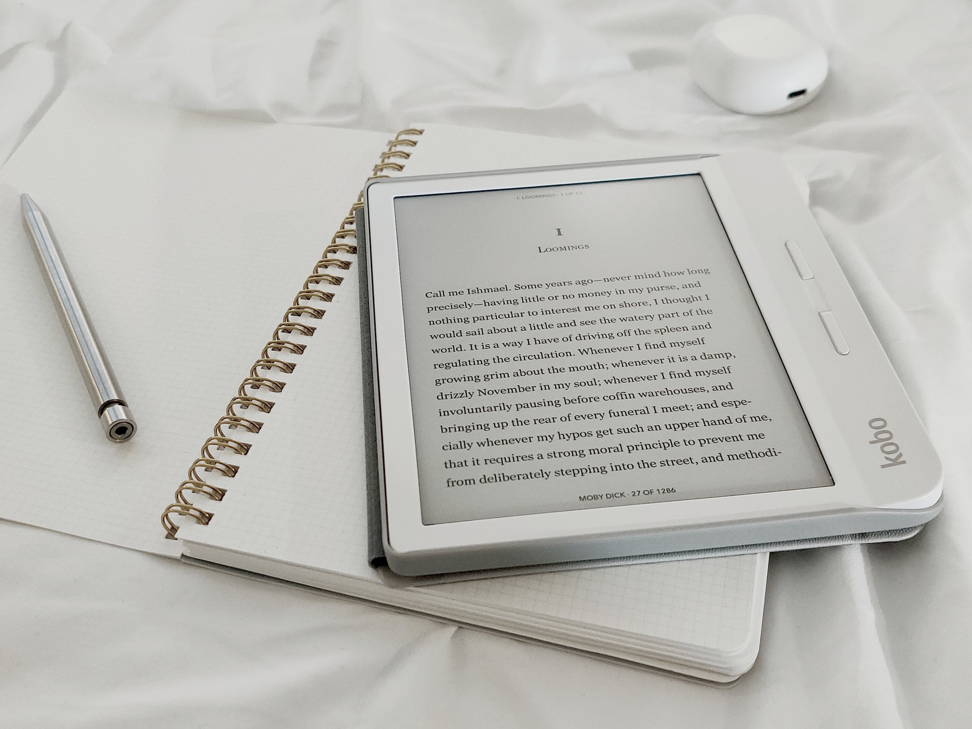 Czytnik e-booków leżący na notesie obok długopisu